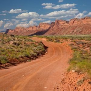 A red dirt road below rock bluffs in Bears Ears National Monument.