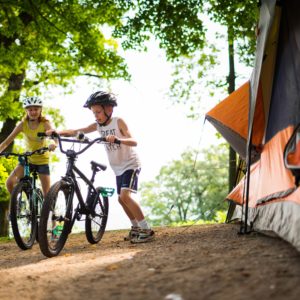 Kids pedal bicycles near a tent at Wyalusing State Park, Wisconsin