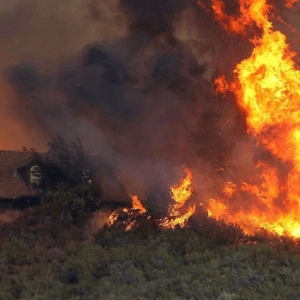 Wildfire burns near a home in California